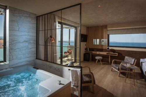 a bathroom with a bath tub and a bedroom at Chania Flair Boutique Hotel, Tapestry Collection by Hilton in Chania Town