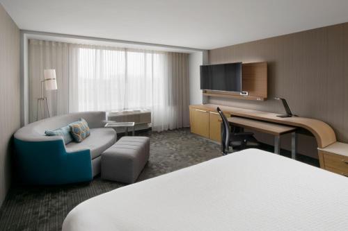 a hotel room with a bed and a desk at Courtyard by Marriott Edina Bloomington in Bloomington