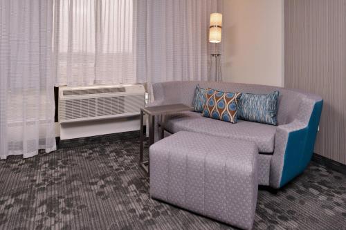 a living room with a couch and a chair and a window at Courtyard by Marriott Edina Bloomington in Bloomington