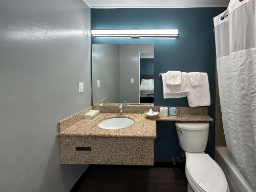 a bathroom with a sink and a toilet and a mirror at Studio 6 Suites Madera, CA Yosemite in Madera