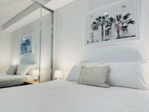 a bedroom with a white bed with palm trees at Cityscape Oasis Homes at Toowong Precinct in Brisbane