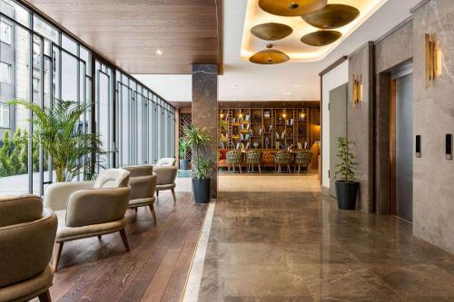 a lobby with chairs and a bar in a building at Days Inn by Wyndham Istanbul Bomonti in Istanbul