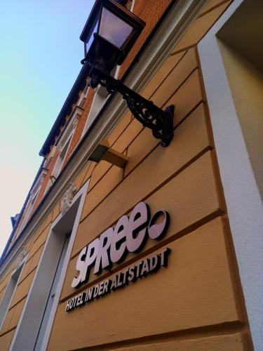 a store sign on the side of a building at SPREE Hotel in der Altstadt in Lübbenau