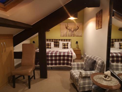 ein Schlafzimmer mit einem Bett, einem Sofa und einem Stuhl in der Unterkunft Harrogate Toffee Loft in Harrogate