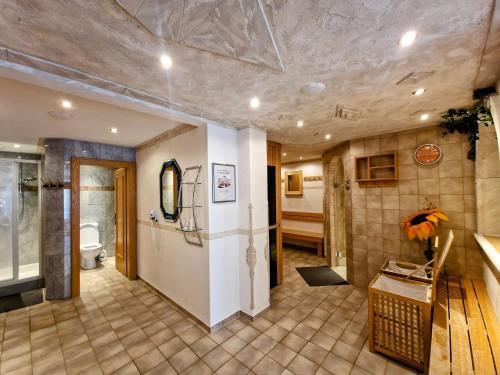 a large room with a bathroom with a refrigerator at Berghotel Almrausch in Berwang
