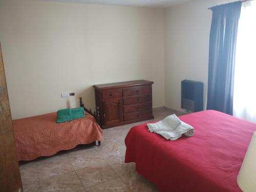 a room with two beds and a dresser in it at Freedom Ame 3 in Río Gallegos