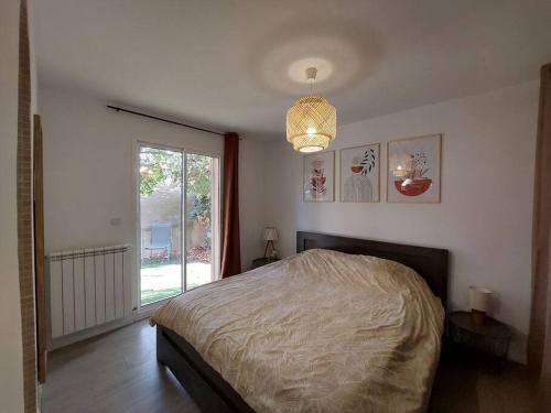 une chambre avec un lit et une grande fenêtre dans l'établissement Appartement t2 avec extérieur, à Toulouges