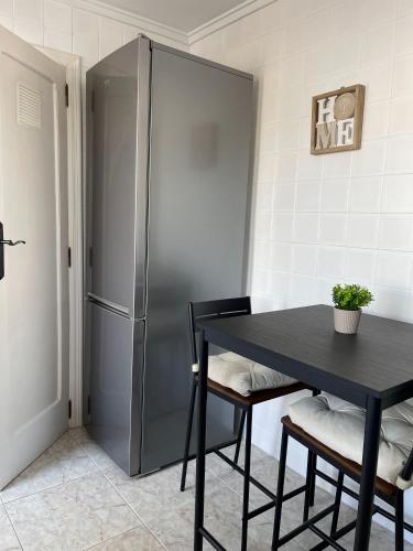 a kitchen with a black table and a refrigerator at RichMarHome in Pego
