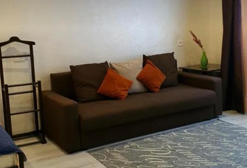 um sofá castanho com almofadas laranja na sala de estar em VIP apart 734 em Tbilisi