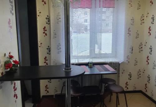 uma mesa e cadeiras num quarto com uma janela em VIP apart 734 em Tbilisi