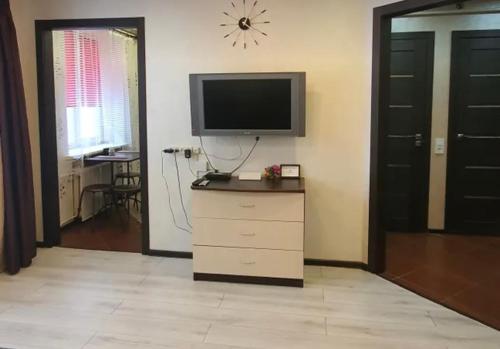 uma sala de estar com uma televisão e uma cómoda com uma televisão de ecrã plano em VIP apart 734 em Tbilisi