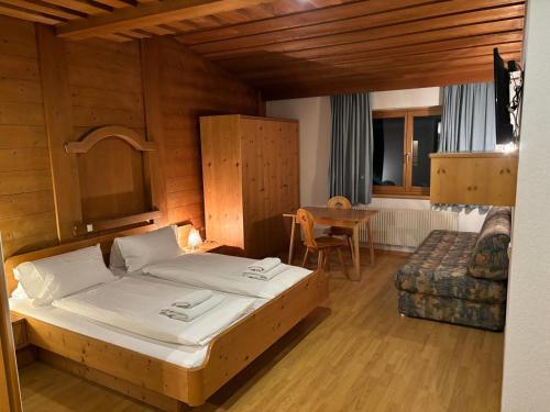 1 dormitorio con 1 cama, 1 mesa y 1 silla en Gasthof Paluda - Pizzeria, en Dalaas