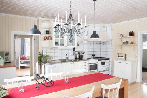 a kitchen with a table and chairs and a chandelier at Torpet i Sjö in Nyland