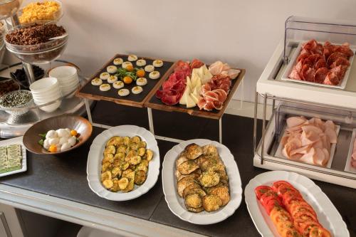 a table with several plates of food on it at Hotel Mozart in Rome