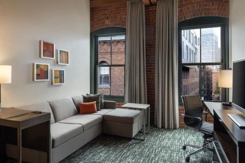a living room with a couch and a large window at Residence Inn by Marriott Boston Downtown Seaport in Boston