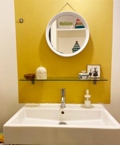 une salle de bain avec un lavabo et un miroir dans l'établissement Havre de paix en plein Paris, à Paris