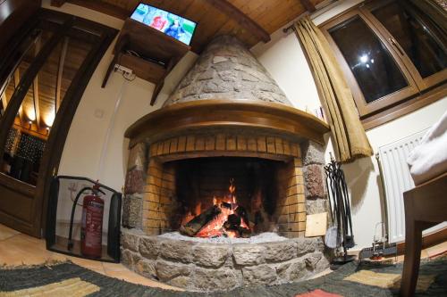 a large brick fireplace with a fire in it at Mont Valley Boutique Chalets in Arachova