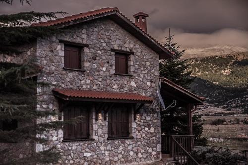 an old stone house with windows on a mountain at Mont Valley Boutique Chalets in Arachova