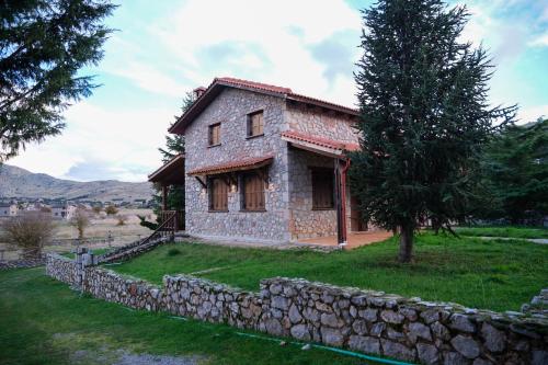 an old stone house with a stone wall at Mont Valley Boutique Chalets in Arachova