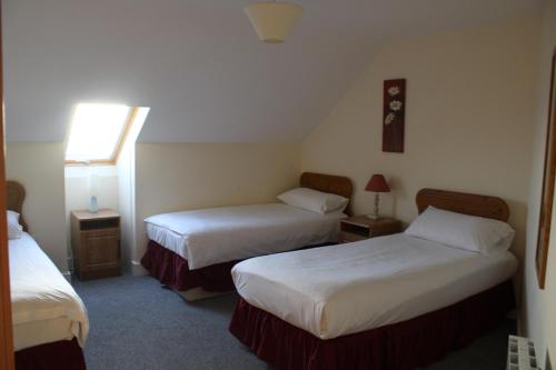 a hotel room with two beds and a window at Dunmore East Holiday and Golf Resort Apartments in Dunmore East