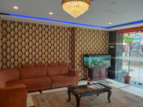 a living room with a couch and a tv at HOTEL NEW MN GRAND in Hyderabad