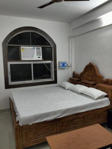 a bedroom with a bed and a window with a air conditioner at Darbar Villa in Bodh Gaya