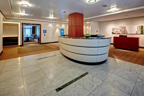 a lobby with a bar in the middle of a room at Hilton Frankfurt Airport in Frankfurt