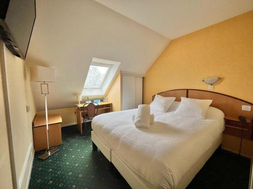 Cette chambre comprend un grand lit et une fenêtre. dans l'établissement Logis Hôtel Sully le Château, à Saint-Père-sur-Loire
