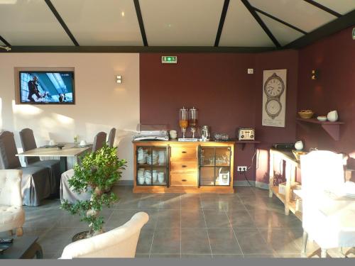 - une salle d'attente avec une table et une cheminée dans l'établissement Hotel Le Saint Aubin, à Chevillé