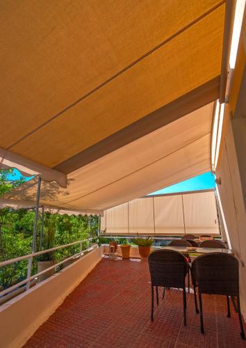 a patio with a table and chairs under awning at Park Hotel in Athens