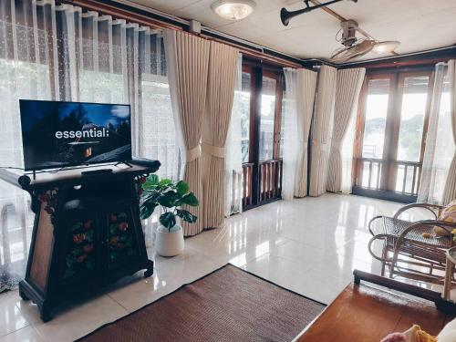 a living room with a laptop on a fireplace at Green Riverside Homestay in Phra Nakhon Si Ayutthaya