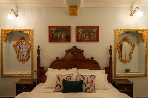 a bedroom with a bed with two mirrors on the wall at Cavalry Villa bikaner in Bikaner