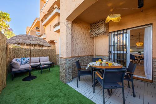 a patio with a table and chairs and an umbrella at Chill-out # Piscina todo el año # Playa a 650m in Vera