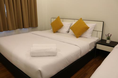 1 dormitorio con 1 cama con almohadas amarillas en V-twin Donjan Service Apartment, en Chiang Mai