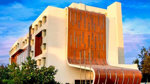a building with a wooden bench in front of it at Holiday Inn Guadalajara Patria-Universidad by IHG in Guadalajara