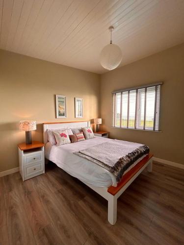 Un dormitorio con una cama grande y una ventana en Dunmore East Ocean View Suite en Dunmore East