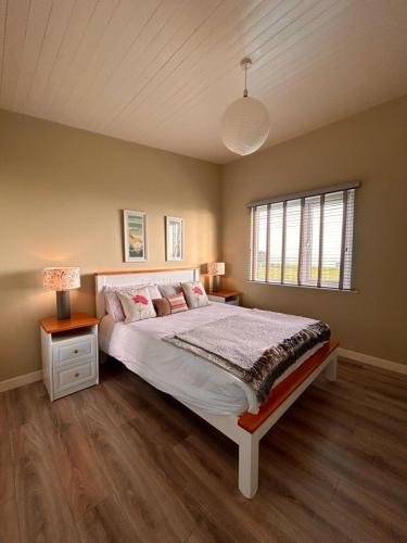 sypialnia z dużym łóżkiem i oknem w obiekcie Dunmore East Ocean View Suite w mieście Dunmore East