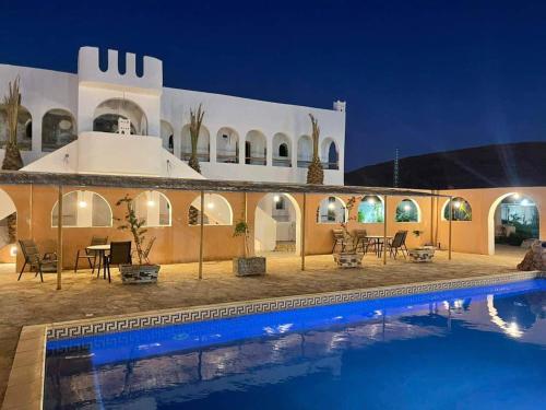 una casa con piscina por la noche en La Villa Tezribt en Ghardaïa