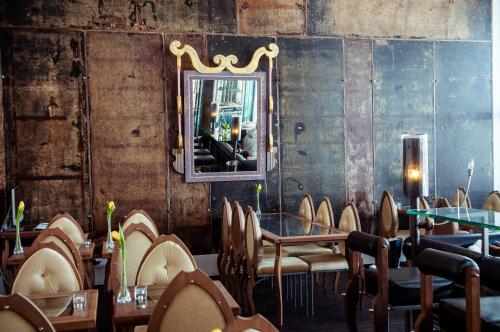 a restaurant with tables and chairs and a mirror at Backstage Boutique SPA Hotel in Zermatt