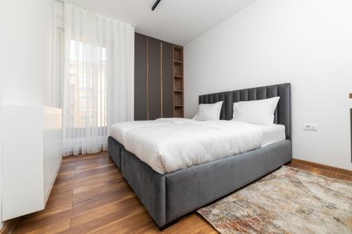 Schlafzimmer mit einem großen Bett mit einem schwarzen Kopfteil in der Unterkunft Emery Apartments in Pristina