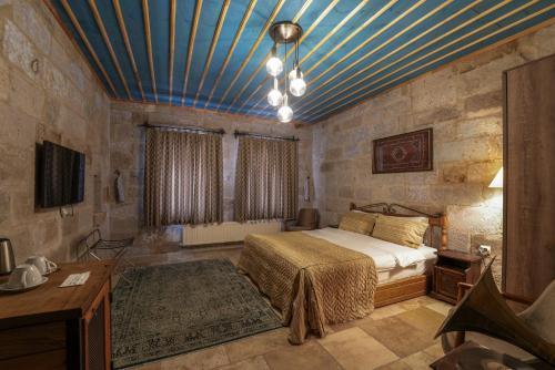 1 dormitorio con 1 cama y techo azul en Tekkaya Cave Hotel, en Göreme