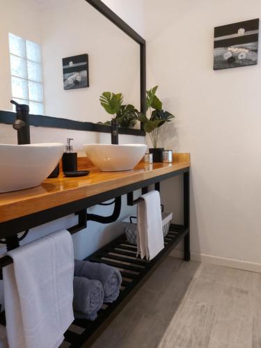 a bathroom with two sinks on a shelf with towels at Tres Deseos in Villa Cura Brochero
