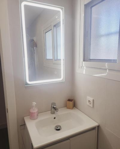 een witte badkamer met een wastafel en een spiegel bij Fuengirola Los Boliches Ronda 3 VISTAS AL MAR Paseo Maritimo At the Promenade with Sea Views in Fuengirola