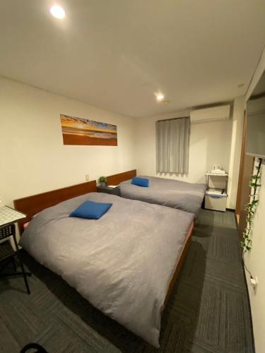 a bedroom with two beds and a desk at MR TOMO FUJI in Fuji