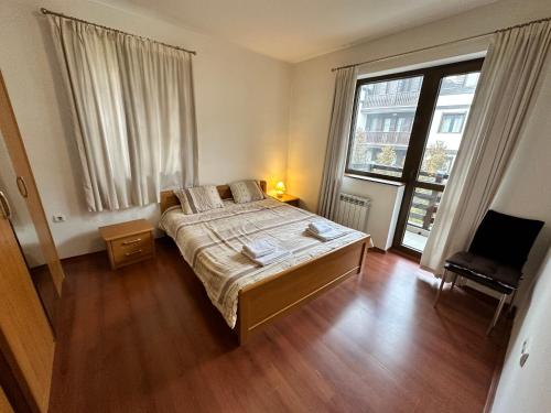 a bedroom with a bed and a large window at Gramadeto two bedroom apartment next to Gondola in Bansko