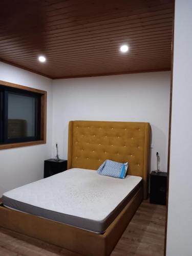 a bedroom with a bed with a headboard and a television at Passadiços do paiva house in Cinfães