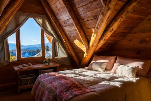 ein Schlafzimmer mit einem Bett in einem Zimmer mit Fenstern in der Unterkunft Pueblo Alto Lodge in Parque Nacional Los Alerces