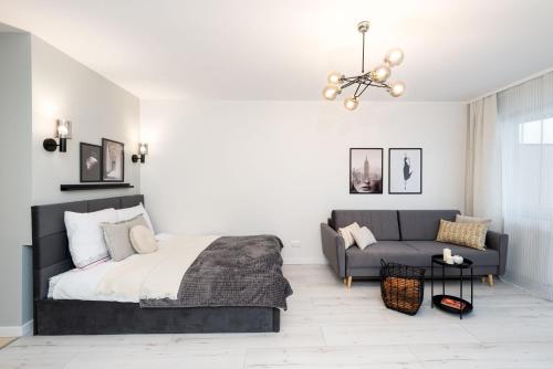 sypialnia z łóżkiem i kanapą w obiekcie Apartament Lothus - parking podziemny gratis, ścisłe centrum - by Kairos Apartments w mieście Gliwice