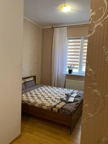 a bedroom with a bed and a window at Відпочинковий комплекс,міні готель Старий дворик in Lviv