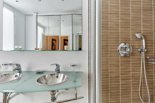 a bathroom with two sinks and a shower at Apartment Arc de Triomphe by Studio prestige in Paris